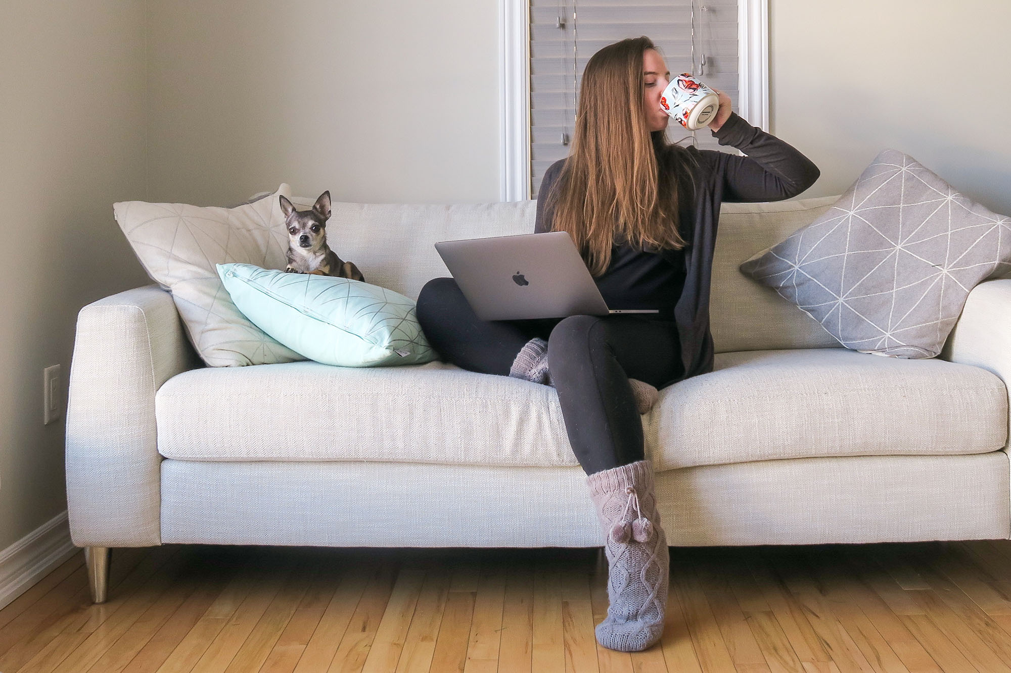 Hannah Warren - Hannah sitting on couch with laptop and chihuahua drinking out of a floral mug cropped2